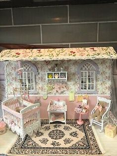 a doll house with furniture and accessories in the living room, including a baby's crib