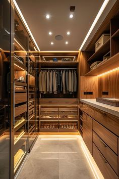 a walk - in closet with wooden cabinets and drawers, lighted by recessed lighting