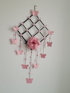 a pink flower and some butterflies on a white wall