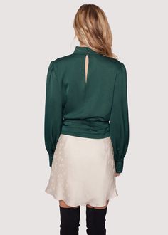 Elevate your style with the Calla Green Wrap Top! This chic piece that's perfect for fall combines a sophisticated mock neck with an open V-neck, elegantly wrapping around the waist and tying into a bow, while long loose sleeves add an extra touch of flair. WTWC02627-2 Imported Model is 5 ft 9 inches; Bust: 32", Waist: 23.5", Hips: 35" and wearing a size Small Runs true to size Hand wash or wash with gentle cycle with cold water with like colors, Air dry to avoid shrinkage. Formal Green Blouse For Fall, Elegant Green High Neck Tops, Chic High Neck Blouse For Fall, Chic High Neck Fall Blouse, Green Top For Date Night In Fall, Elegant Green Blouse For Night Out, Chic Green Blouse For Night Out, Green V-neck Blouse For Date Night, Elegant Green Blouse For Date Night