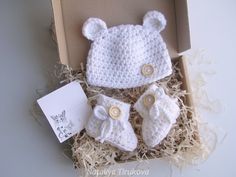 a white crocheted bear hat, booties and diaper set in a box