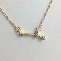 a gold necklace with two tiny stars hanging from it