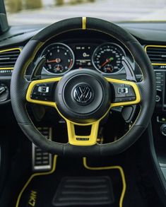 the interior of a car with yellow trims and black steering wheel, dash lights and gauges