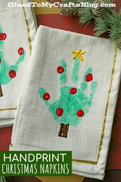 two handprinted christmas napkins on top of a table