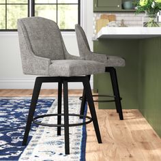 two gray stools sitting on top of a wooden floor in front of a kitchen counter