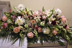 a bunch of flowers that are sitting on a table in front of a mirror,