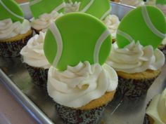 cupcakes with green and white tennis balls on top are lined up in a row