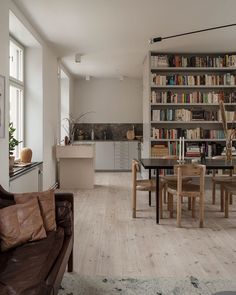 a living room filled with furniture next to a book shelf covered in lots of books