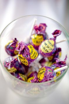 a glass bowl filled with purple and yellow candies