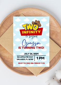 two infinity is turning two birthday party card on a wooden platter with cotton floss