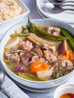 a bowl filled with meat and vegetables next to rice