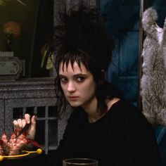 a woman sitting at a table with food in front of her