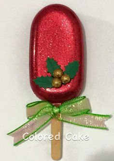 a red lollypop with holly and gold decorations