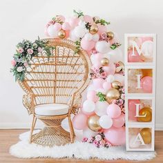 the balloon wall is decorated with pink, gold and white balloons for an elegant touch