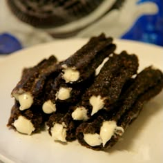 some cookies and ice cream are on a white plate next to an oreo cookie