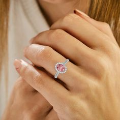 a woman's hand with a pink diamond ring