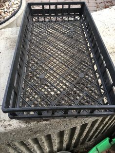 a metal basket sitting on top of a sidewalk