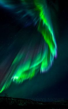 the aurora bore is glowing brightly in the night sky, with green and purple lights