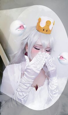 a woman with white hair wearing a tiara and holding her hands to her face