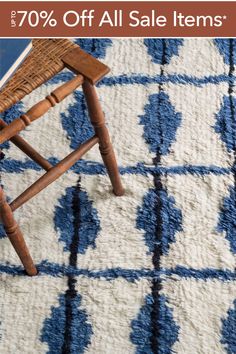 a wooden chair sitting on top of a blue and white rug with the words 70 % off all sale items