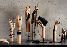 several wooden mannequins with hands and chains around them, all holding objects