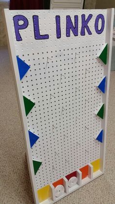 a sign that says plinko in front of a door with pegs on it