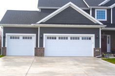 a large gray house with two garage doors