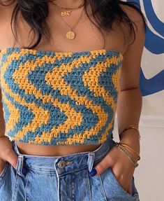 a close up of a person wearing a top with crocheted designs on it