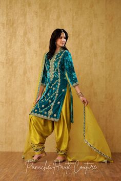 "Teal Blue Royal Silk Velvet Kameez with Hand Embroidery and Chartreuse Yellow Silk Salwar: A Luxurious Punjabi Suit for Women" This stunning Punjabi suit combines the richness of teal blue silk velvet with the delicate hand embroidery to create a truly regal look. The kameez features intricate hand embroidery, adding to its luxurious appeal. The salwar is made of chartreuse yellow silk fabric, also with hand embroidery, which perfectly complements the teal blue kameez. To complete the tradition Designer Turquoise Sets With Resham Embroidery, Turquoise Sharara With Resham Embroidery For Eid, Bollywood Style Embroidered Turquoise Sets, Designer Turquoise Set For Eid, Turquoise Set For Eid, Turquoise Dabka Work Sets For Eid, Unstitched Turquoise Salwar Kameez With Resham Embroidery, Eid Turquoise Sets With Dabka Work, Festive Turquoise Set With Dabka Work