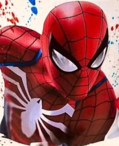 spider - man is sitting on the ground in front of paint splattered walls