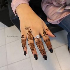 a woman's hand with henna tattoos on it