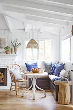 a living room filled with furniture and a fire place next to a table in front of a fireplace