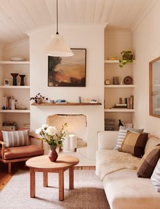 a living room filled with furniture and a fire place under a painting on the wall