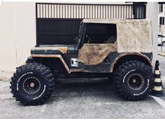 an old jeep parked in front of a garage