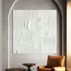 a chair and table in front of a wall with an abstract design on the wall