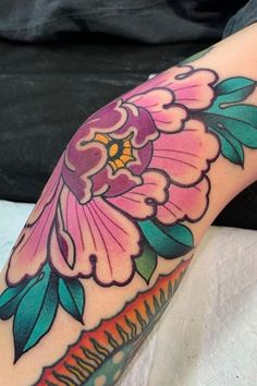 a woman's arm with a flower tattoo on it