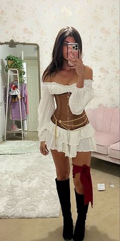 a woman is taking a selfie in a mirror wearing a corset and boots