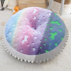 a round pillow with stars and unicorns on it in the middle of a room