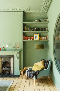 a living room filled with furniture and a fire place next to a wall mounted book shelf