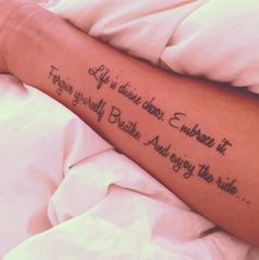 a person with a tattoo on their arm that says, life is divine when it begins