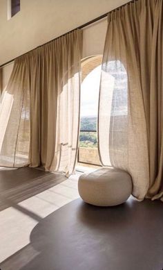 a room with large windows and curtains in it