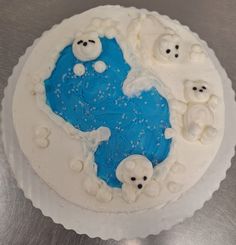 a cake with white frosting and blue icing on top of a silver table