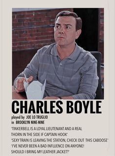 a man sitting at a table in front of a sign that says charles boyle