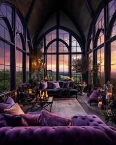 a living room filled with lots of furniture and large windows overlooking the ocean at sunset