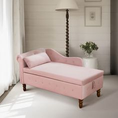 a pink chaise lounge in a white room