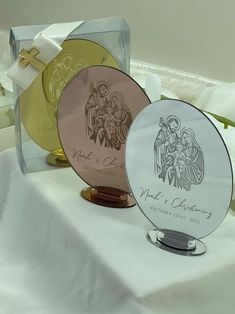 two glass plates sitting on top of a white tablecloth covered table with gold and silver decorations