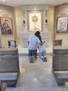 two people sitting on the ground in front of a church alter