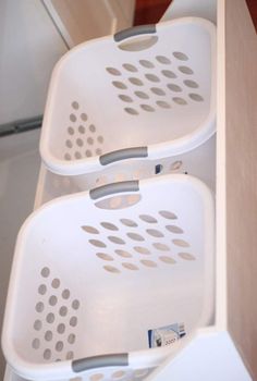 three white baskets are stacked on top of each other in the kitchen cabinet door drawer