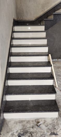 a set of black and white stairs leading up to the second floor