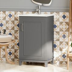 a bathroom vanity with a mirror above it and a stool next to it in front of a tiled wall